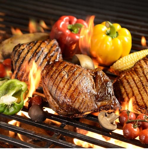 grilled meat steak with vegetable on the flaming grill